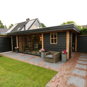 Moderne houten tuinkamer met overkapping, glazen schuifwanden en aangrenzende berging voor extra opbergruimte.